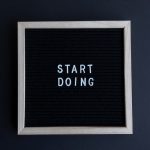 Black letter board with the motivational phrase 'Start Doing' in white text on a gray background.